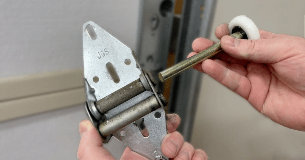 Hand holding a garage door roller