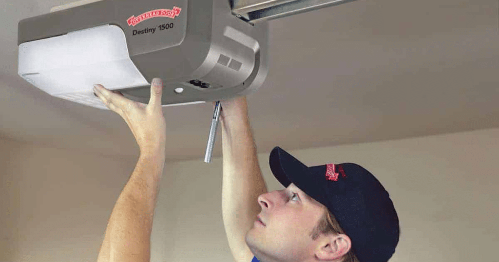 Technician installing garage door opener unit.